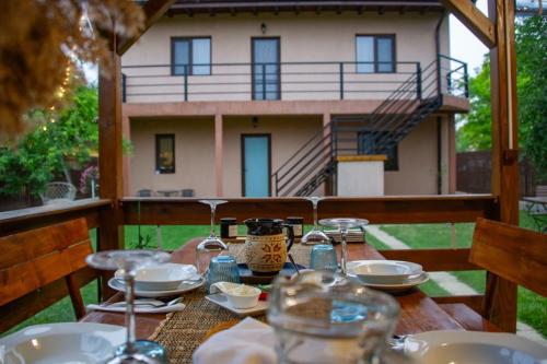 een houten tafel met borden eten en een huis op de achtergrond bij Casa lui Matei Murighiol in Murighiol