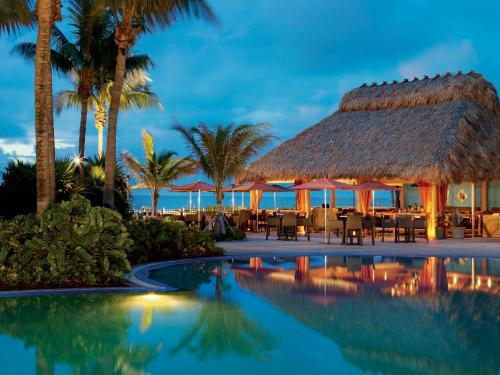a resort with a pool and a restaurant with palm trees at Lovely Deluxe Unit Located at Ritz Carlton - Key Biscayne! in Miami