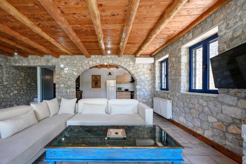a living room with a stone wall at Manousaki in Lambiní