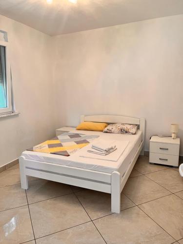 ein weißes Bett in einem Zimmer mit einer weißen Wand in der Unterkunft Apartments Apartmani Bojana in Utjeha