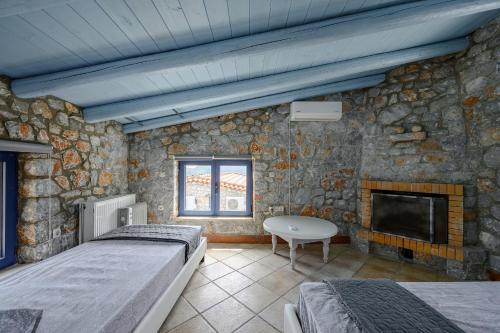 a bedroom with two beds and a stone wall at Rozare in Lambiní