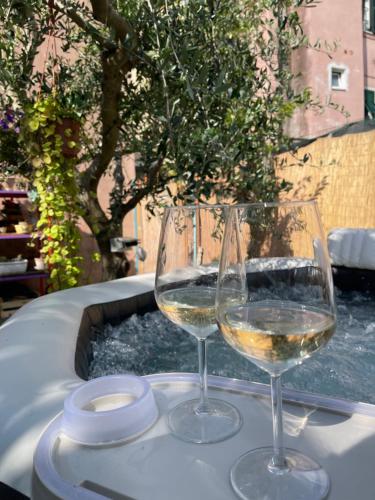 due bicchieri di vino bianco seduti su un tavolo di Sky Room - Carrara Nel ex Convento delle Suore a Carrara