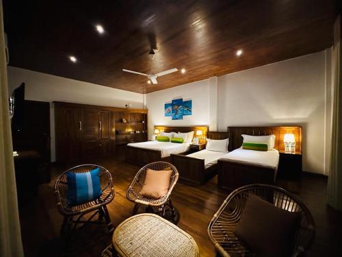 um quarto com duas camas e cadeiras num quarto em Lagoon gate Tangalle Resort em Tangalle