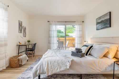 a white bedroom with a bed and a table at Wren Home in Concord