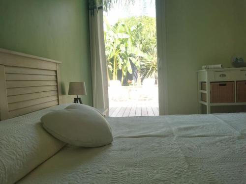 a white bed with a pillow sitting on top of it at La petite Niçoise au Jacuzzi à 3 min de la mer in Nice