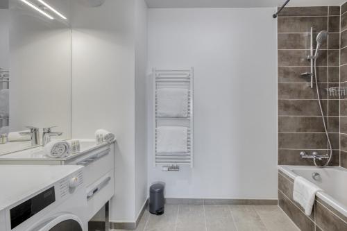 La salle de bains blanche est pourvue d'un lavabo et d'une baignoire. dans l'établissement View Point Lac d Annecy, à Annecy