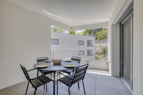 une salle à manger avec une table et des chaises sur un balcon dans l'établissement View Point Lac d Annecy, à Annecy