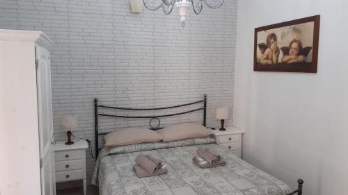 - une chambre avec un lit, 2 tables de chevet et un mur en briques dans l'établissement La Tana nel Vicolo, à Santa Marinella