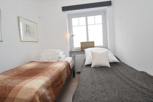 a bedroom with two beds and a window at fewo1846 - Am Walfischstein - strandnahe 2-Zimmer-Wohnung im 1 OG in eleganter Jugendstilvilla in Westerholz