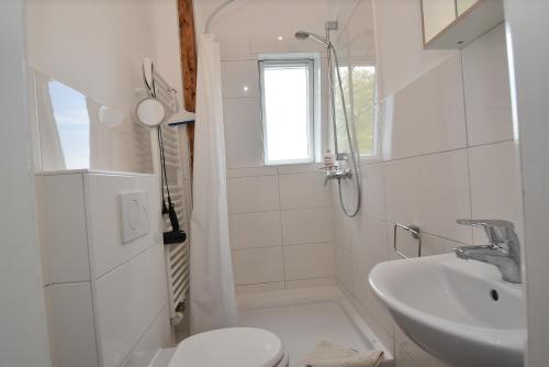 a white bathroom with a sink and a toilet at fewo1846 - Am Walfischstein - strandnahe 2-Zimmer-Wohnung im 1 OG in eleganter Jugendstilvilla in Westerholz
