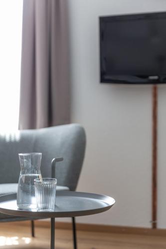 a glass cup on a table in front of a chair at Alpenblick Bern - kind of a hotel in Bern