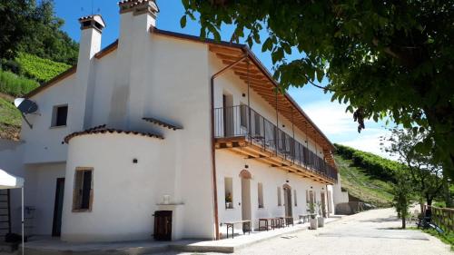 a white building with a balcony on the side at Agriturismo La Pina in Tarzo