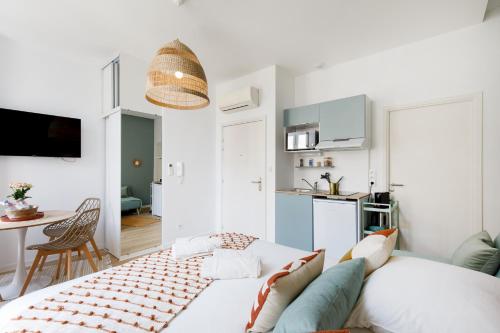 een witte woonkamer met een bank en een keuken bij Studio centre cannes in Cannes