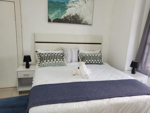 a bedroom with a large white bed with pillows at Pro Delux inn in Durban