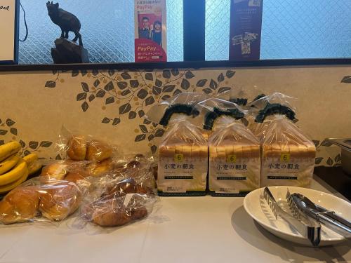 a table with bags of bread and bananas on it at Miro Kyoto Nijo Hotel in Kyoto