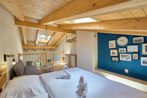 a bedroom with a white bed and a blue wall at Charming and quiet apartment in Lipno nad Vltavou
