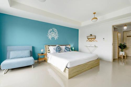 a bedroom with a bed and a blue wall at Turtle Rooms in Bang Tao Beach