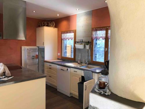 a kitchen with orange walls and white appliances at Maison de campagne in Mens
