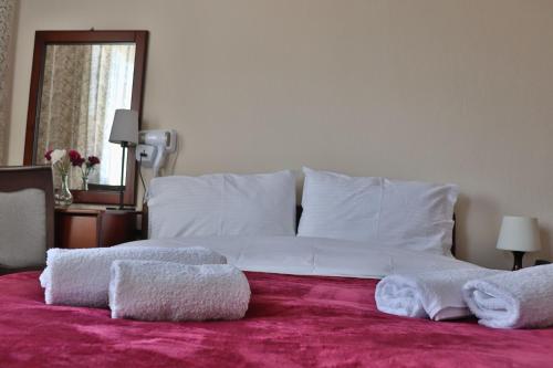 a bedroom with a large white bed with towels on it at Hotel Mitikas in Livádion