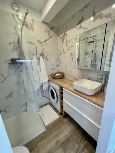 une salle de bain avec douche et lavabo et une machine à laver dans l'établissement Superbe studio avec terrasse proximité plage, à Saint-Mandrier-sur-Mer