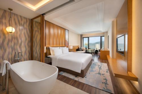 a hotel room with a bed and a bath tub at Grand Hyams Hotel - Quy Nhon Beach in Quy Nhon