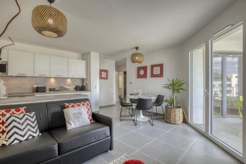 un salon avec un canapé et une cuisine dans l'établissement View Point City, à Annecy