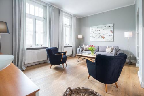 a living room with a couch and a table and chairs at Kapitänshaus 1935 in Norderney