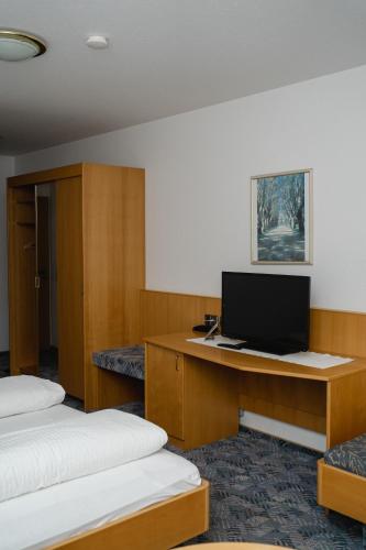 HeergasseにあるHotel Sternenのベッド2台、デスク、テレビが備わる客室です。