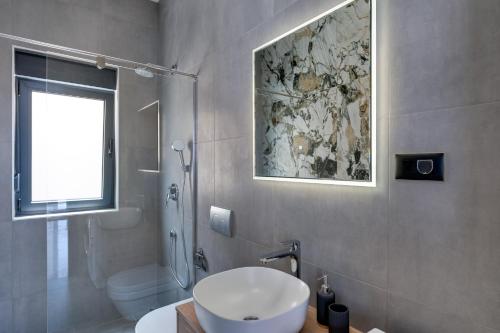 baño con lavabo y aseo y ventana en Luxury villa Verbenico Hills- amazing sea view, pool with whirpool and waterfall, beach, in famous wine region - Your holiday with style, en Vrbnik