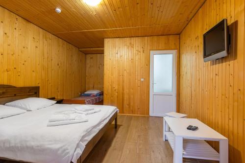 a bedroom with a bed and a tv on a wall at ROMANTIK in Solotvyno