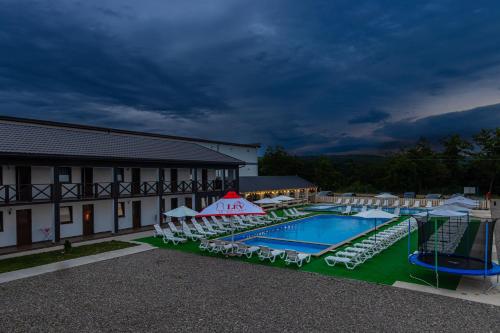 a view of a hotel with a pool and chairs at ROMANTIK in Solotvyno