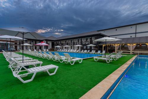 a row of lounge chairs next to a swimming pool at ROMANTIK in Solotvyno