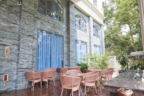 a group of chairs and tables in front of a building at Khang Thịnh Hotel Long Thành in Long Thành