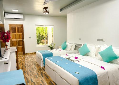 福拉杜島的住宿－Island Luxury Dive Hotel - Fulhadhoo，蓝色和白色的客房内的两张床