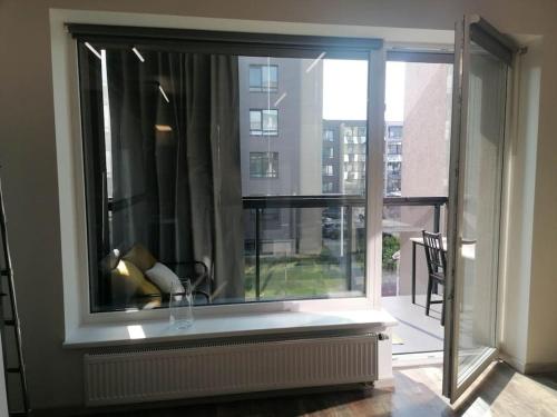 ventana grande con vistas a un edificio en Erdvi studija Spacious studio apartment Self check in, en Vilna