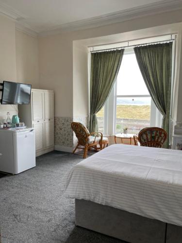 a bedroom with a bed and a large window at Seascape in Barmouth