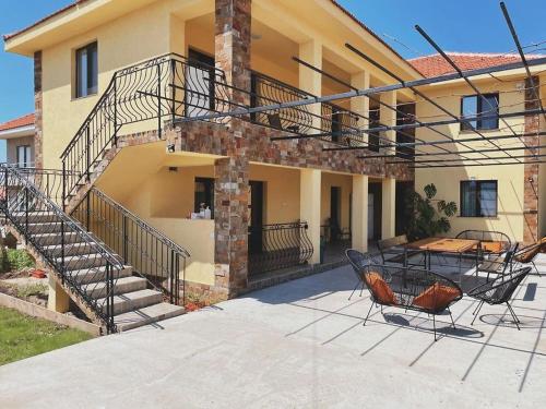 Un patio con una mesa y sillas frente a una casa. en The sweet house, en Vama Veche