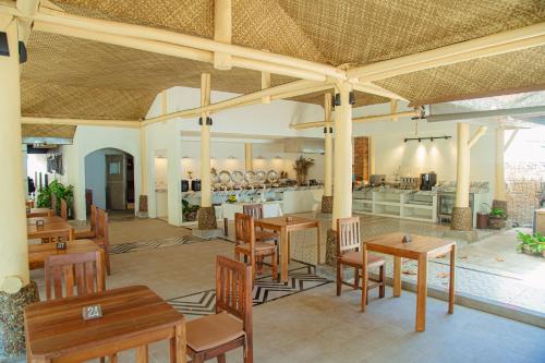 a restaurant with wooden tables and chairs and a kitchen at Railay Village Resort and Spa in Railay Beach