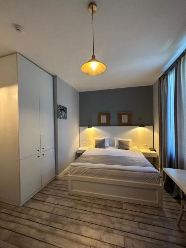 - une chambre avec un grand lit blanc et une table dans l'établissement Hotel Ticiani 13, à Koutaïssi
