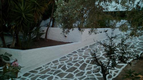 a white walkway in a garden with trees and plants at Amaranthos Skiathos View in Megali Ammos