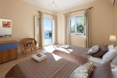 a bedroom with two beds and a view of the ocean at Villa Kyma, Kaminaki Villas in Corfu With Private Pool And Spectacular Sea Views in Agní
