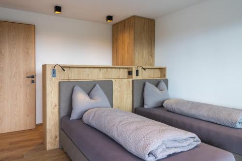 - 2 lits avec des oreillers dans une chambre dans l'établissement Beim Lackl, à Avelengo