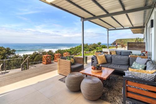 Una sala de estar al aire libre con un sofá y una mesa. en Morgan Bay Hotel, en Morganʼs Bay