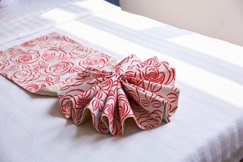 a pair of ties with roses on a bed at Khang Thịnh Hotel Long Thành in Long Thành