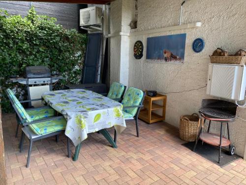 une terrasse avec une table, des chaises et une cuisinière dans l'établissement LE PETIT RENARD, à Dabo