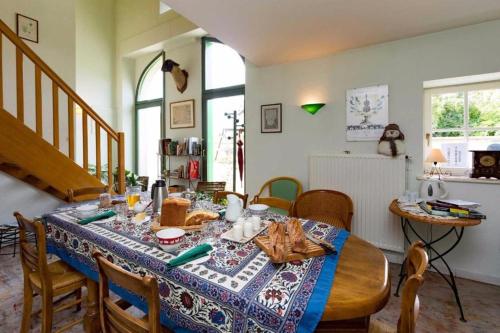 a dining room with a table with a blue table cloth at Une Poule Sur un mur, chambre d'hôte à Soulosse in Soulosse-sous-Saint-Élophe