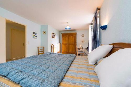 a bedroom with a large blue bed in a room at Une Poule Sur un mur, chambre d'hôte à Soulosse in Soulosse-sous-Saint-Élophe