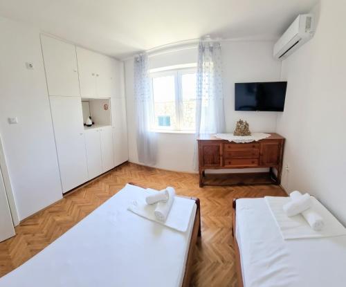 una camera con 2 letti e una TV di APARTMENT LEA BAYVIEW a Dubrovnik