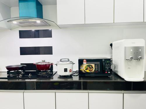 a kitchen with a counter top with a toaster and a microwave at Anjung Rindu Homestay (Kuala Terengganu, UMT, UniSZA) in Kuala Terengganu