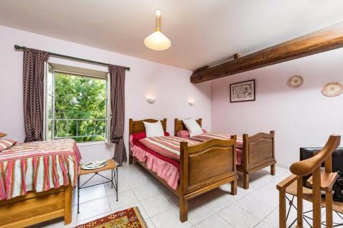 1 dormitorio con 2 camas y ventana en Jolie vache déguisée en fleurs, chambre d'hôte à Soulosse, en Soulosse-sous-Saint-Élophe